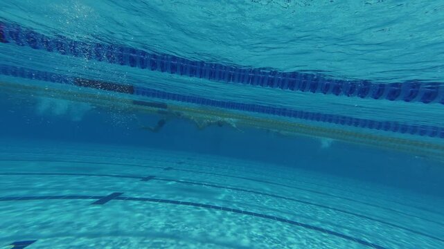 Underwater View of Swimming Pool Lanes with Swimmers in Distance