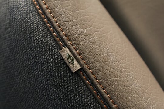 Closeup of stitched leather and fabric upholstery with eco label for sustainable interior design branding
