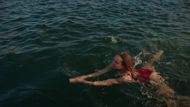 Woman swimming in the sea for an open water wellness ritual