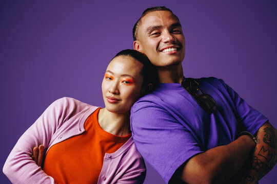 Together, friends smile close to the camera in a studio portrait