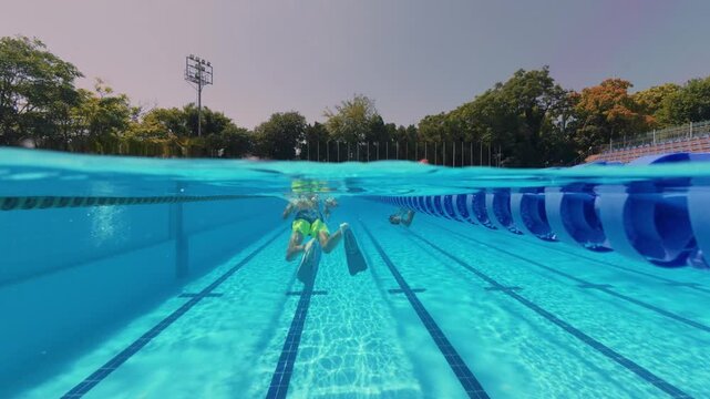 Split View Boy Swimming Underwater with Flippers in Pool