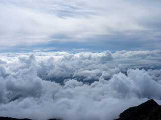 Naklejka premium Towering Summer Clouds Forming a Dramatic Sea of Clouds Above the Mountains