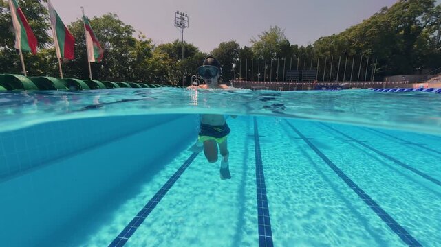 Split View Boy Swimming with Flippers and Mask in Outdoor Pool