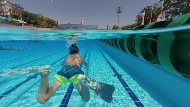 Split View Boy Swimming Underwater with Flippers in Pool