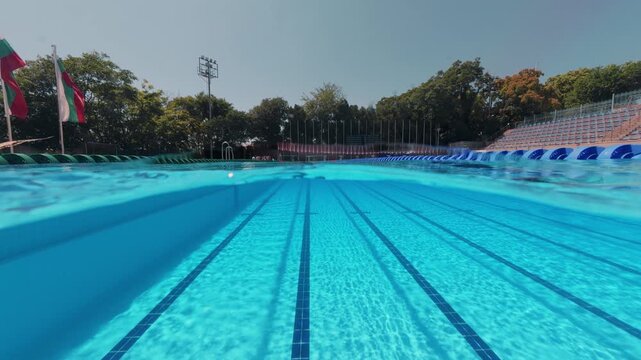 Split View Outdoor Swimming Pool Lanes with Swimmer in Distance