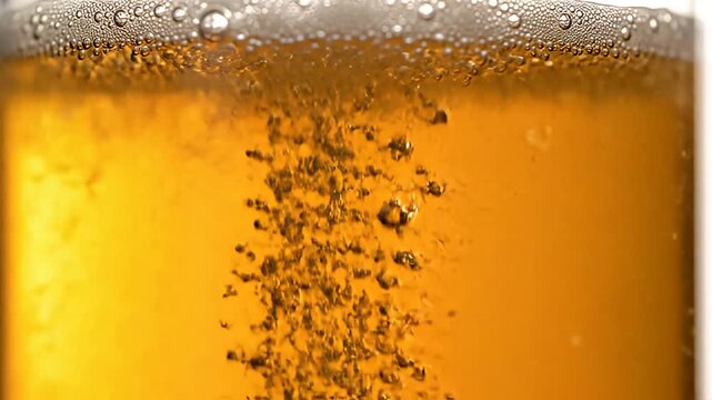 Close-up of bubbling amber beer in a glass.