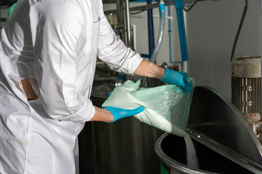 Man pouring Flour In Mixing Machine in industrial factory. Middle-aged manager with expertise