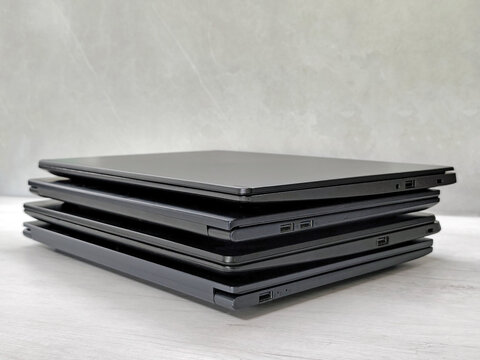 stack of laptops on a gray background, on the table, laptop computer, tablet, business, work, remote work, freelance.
