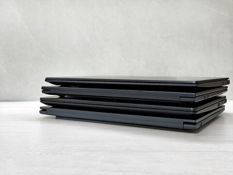 stack of laptops on a gray background, on the table, laptop computer, tablet, business, work, remote work, freelance.

