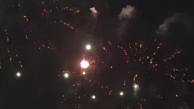 Red and gold fireworks exploding together in night sky