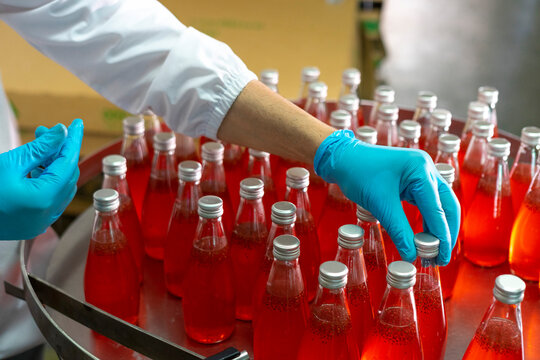 Close-up of the hands  in production line of the factory for bottling beverages. Production of beverages.
