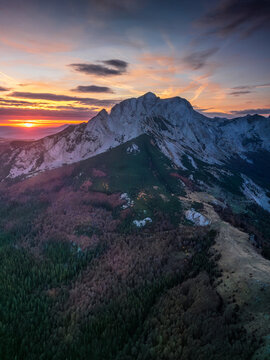 Aerial view of the dramatic peaks of Sutjeska National Park during a vibrant sunset with dense autumn forests and rugged mountain terrain in Tjentiste, Republika Srpska, Bosnia and Herzegovina.