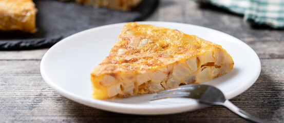 Slice of Traditional Spanish Potato Omelette on wooden table