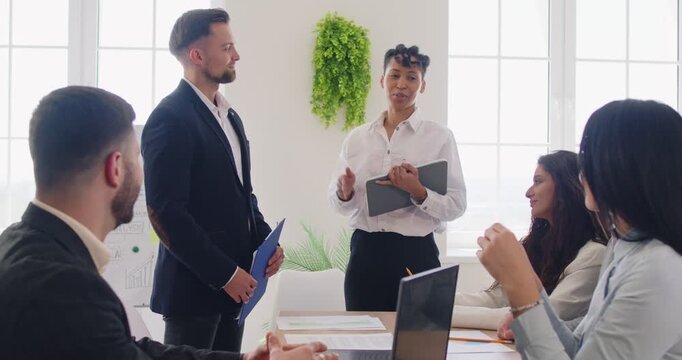 Office introducing new member to group of diverse businesspeople listening and discussing, conducting a collaborative meeting, acquainted, recommendation, high five applauding to agree, deal