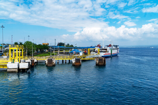Gilimanuk, Bali, Indonesia, August 06, 2026: Passenger ferry ship docked at a harbor terminal pier on a sunny day with deep blue ocean water and blue sky.