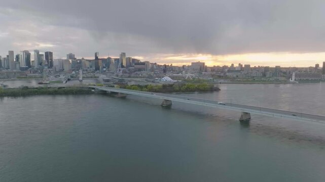 drone side move overloking mainly the city of montreal in the old port circle du soleil port buildings n sun in the background