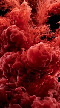 Crimson ink mixes with water in a clear container, creating shapes and patterns that change over time. This motion captures attention.