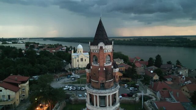 Cinematic drone view of Gardos Tower with dramatic stormy twilight sky and Danube river in the background, Zemun, Belgrade, Serbia.