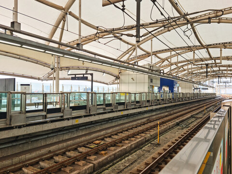 Modern Elevated Train Station Platform and Railway Tracks Under Canopy
