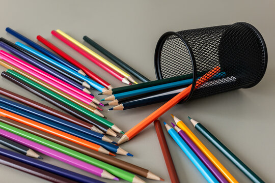 Colorful Pencils Spill from a Black Mesh Holder