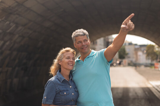 Man pointing out a landmark to a smiling woman