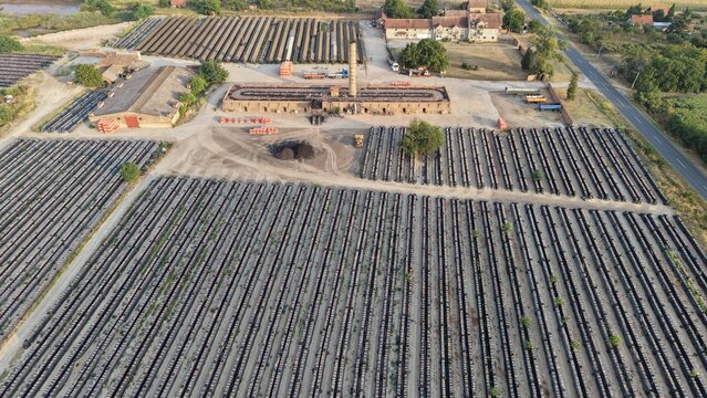 Aerial view of the historic Ciglana brick factory featuring long rows of drying bricks, industrial buildings, and a tall chimney in Pancevo, Serbia.
