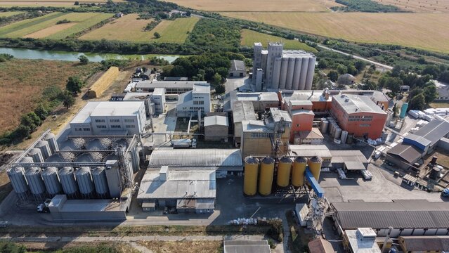 Aerial view of the Severna zona industrial facility in Pancevo, featuring large grain silos, storage tanks, and factory buildings surrounded by agricultural fields in Pancevo, Serbia.