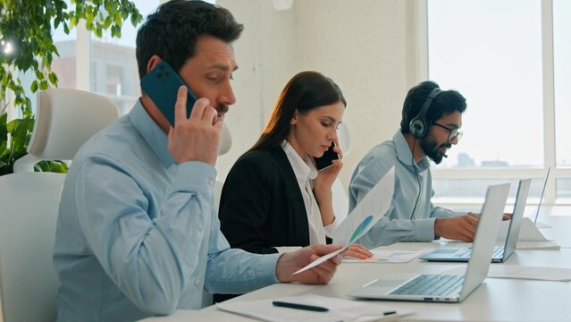 Diverse business team working laptops help customer service call center indoor office businessmen businesswoman talking mobile phone callcenter answering sales calls using computers teamwork support