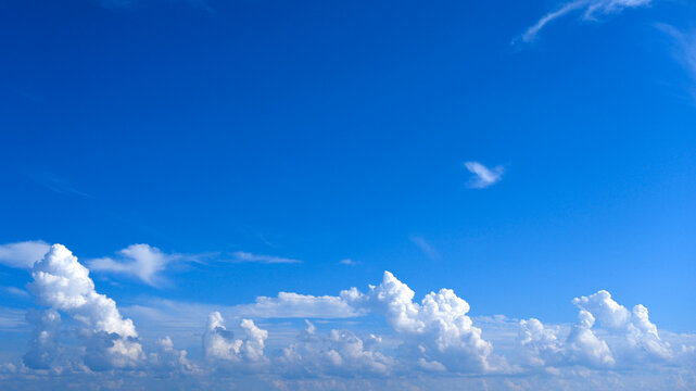 White balls of cloud in the summer blue sky, clean and fluffy, perfect for wallpaper.