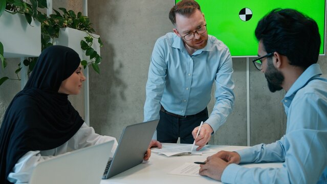 Multiethnic business team brainstorming indoor office boardroom discussing project corporate colleagues businessmen muslim hijab businesswoman talk meeting screen chroma key interactive board mock up