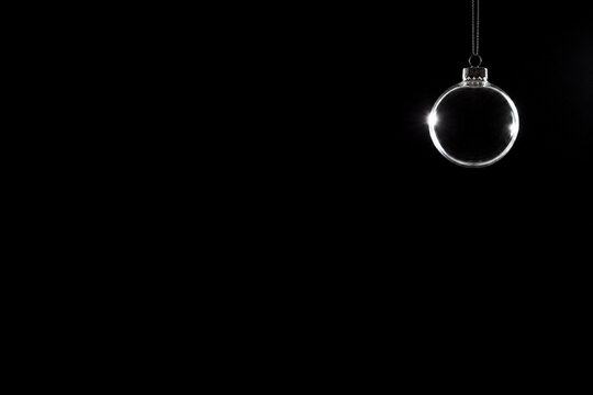 A clear glass ornament photographed backlit so it reads as a luminous