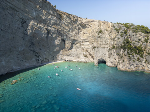 Aerial view of the turquoise waters and dramatic limestone cliffs of the Blue Caves in Zakinthos, Greece.