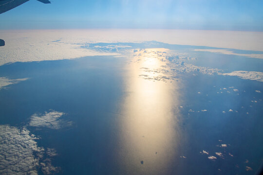 Aerial Sun Reflection On Ocean Through Clouds