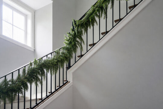 A staircase banister wrapped with a simple undecorated evergreen
