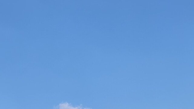 Time lapse of daytime blue sky with clouds slowly disappearing leaving a clear empty sky