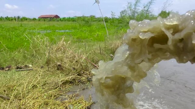 Muddy water splashing into pond