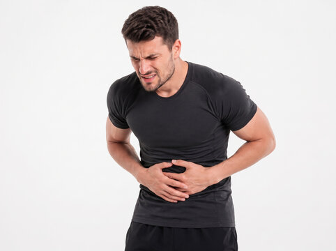 Young Athletic Man In Black Sportswear Suffering From Severe Abdominal Pain Isolated On White Background, Healthcare And Medical Symptom Concept
