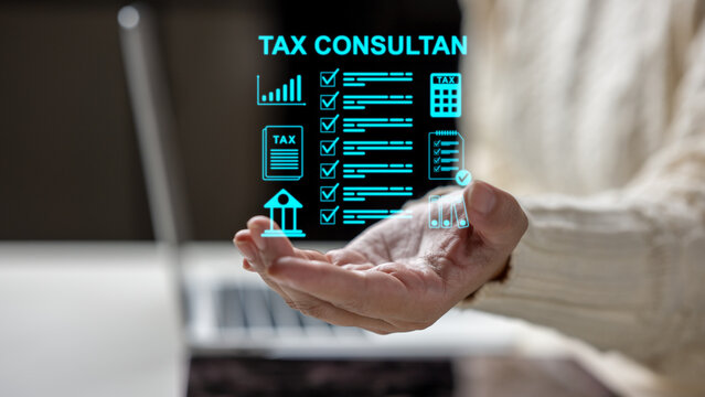 A person holding a digital holographic interface showcasing tax consultant services, checklists, and financial icons with a laptop in the background. Concept of a Tax Consultant