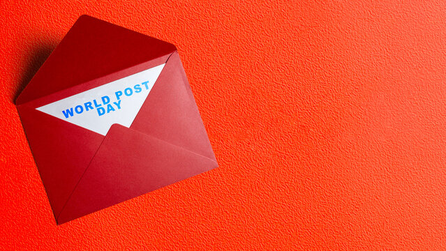 Red open envelope with a white card reading "World Post Day" on a textured orange background. Concept of World Post Day