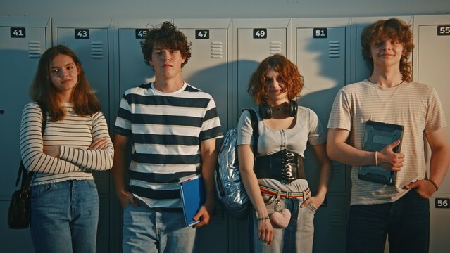 Teenage Standing Against School Lockers, Sharing Laugh and Talking, Wearing Casual Trendy Clothes and Holding School Supplies. School Life Socialization, Modern Youth Lifestyle on Campus. Portrait.