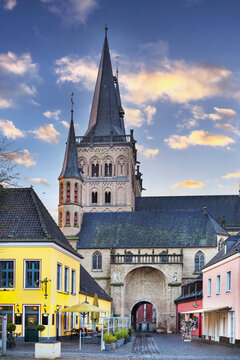 View from main square through archway to Xanten Cathedral, Germany. Sunset sky with warm evening light