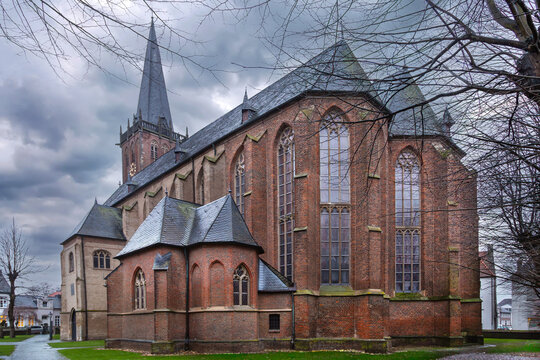 Gothic apse of St. Nicholas Church in Kalkar, Germany, shot from a low angle. Rainy daylight under a cloudy grey sky