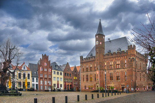Historic houses and town hall on main square in Kalkar, Germany. Rainy daylight under a cloudy grey sky