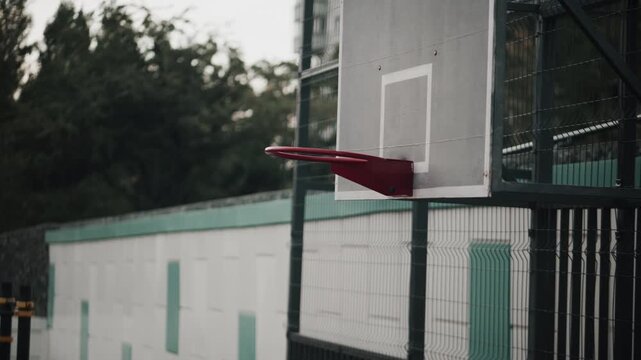 Close up of basketball in motion toward hoop on outdoor court during game action