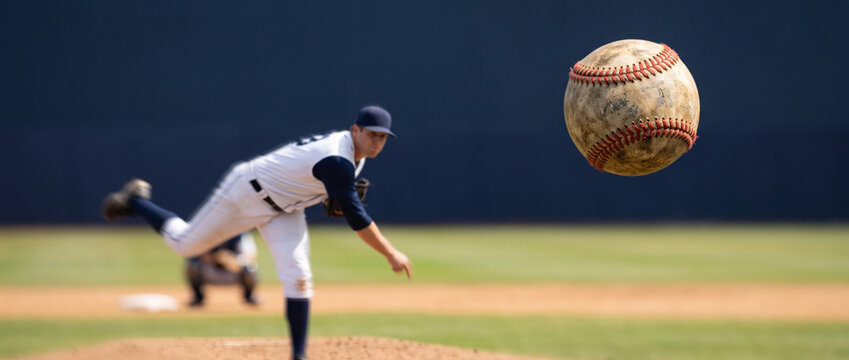 Baseball pitcher in action throwing a ball during a game on a sunny day
