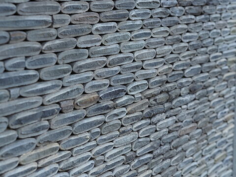 Texture of a fence made of decorative stonework made of gray sea pebbles