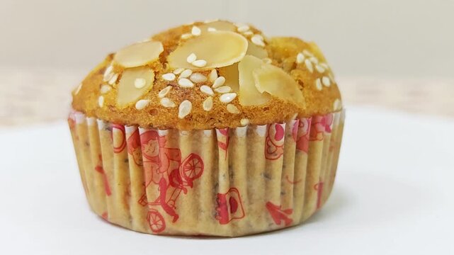 Healthy grain muffin with almonds and white sesame seeds.