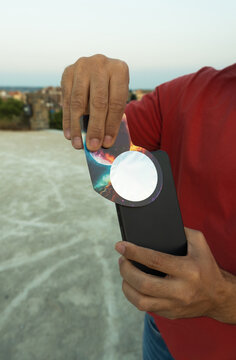 Person holding phone with space cover and solar filter
