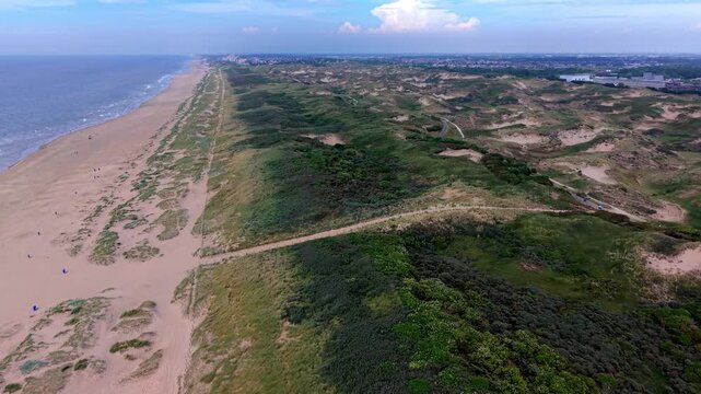 Aerial view video clip of Katwijk aan Zee coastal sand dunes landscape, sandy beach shoreline, Scheveningen distant skyline, and North Sea horizon in South Holland, Netherlands