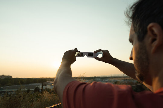 Man observing solar event with protective eclipse glasses